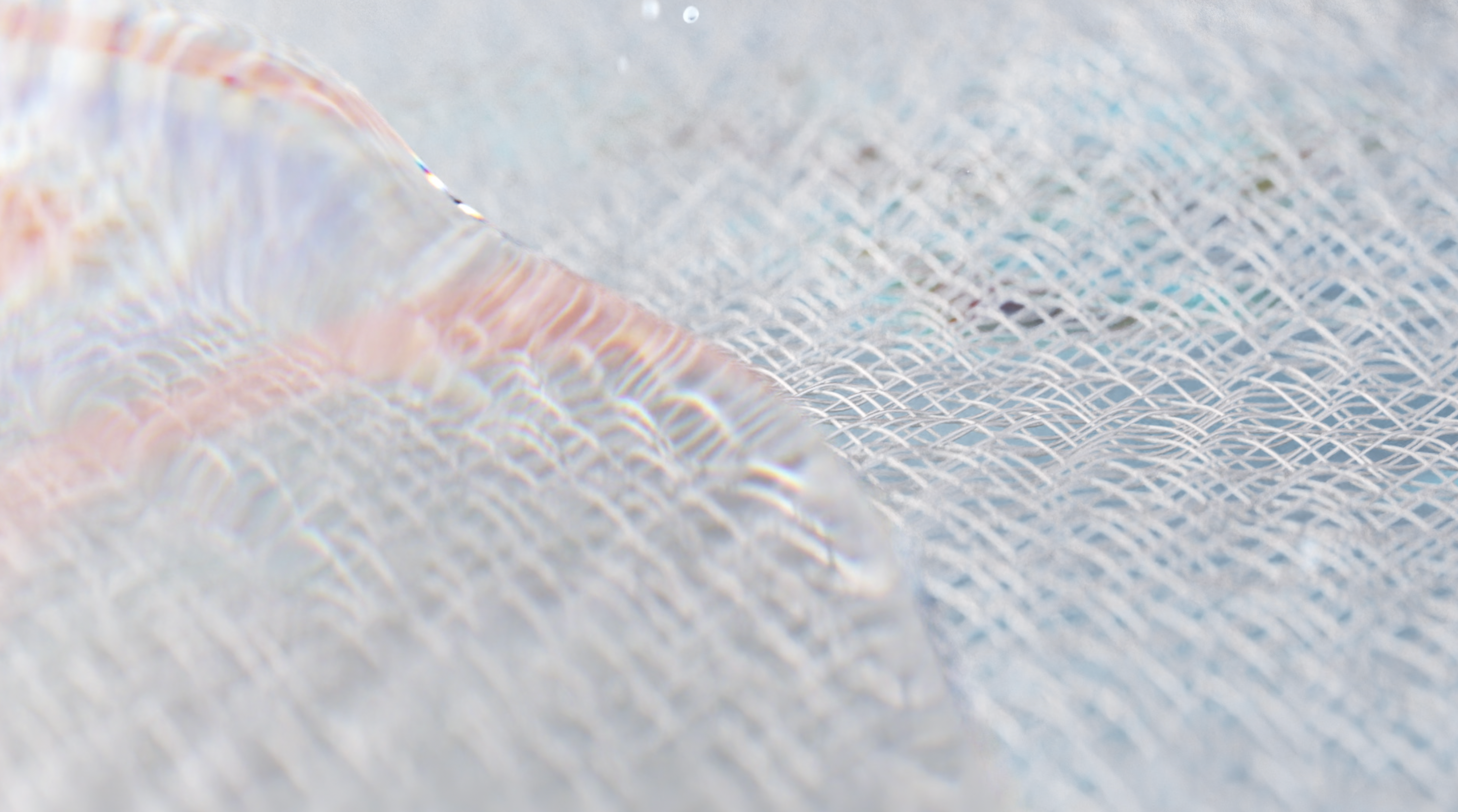 Close-up of a delicate, light-reflecting, and textured surface, resembling a mesh or woven fabric. The light creates a spectrum of soft, iridescent colors across the surface, adding a sense of depth and shimmer to the intricate pattern.
