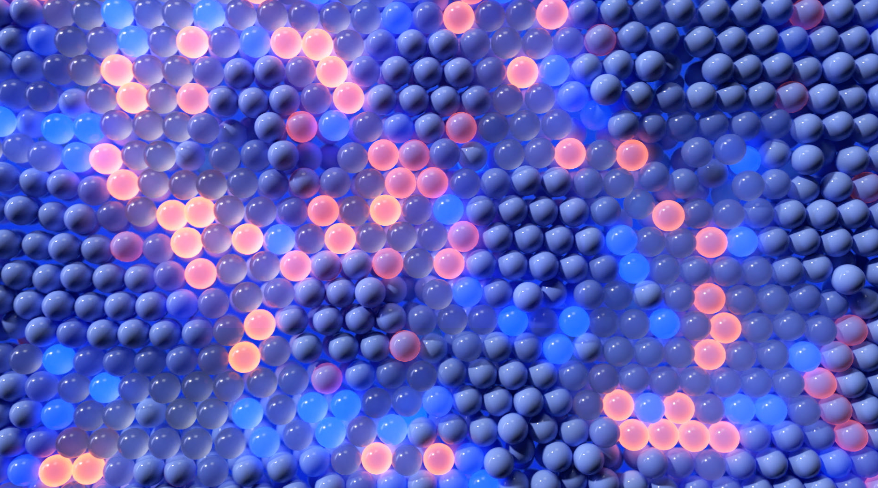 An abstract image showing a dense collection of translucent spheres in various shades of blue, pink, and purple. The spheres are illuminated, creating a glowing effect, and are arranged in a honeycomb-like pattern.